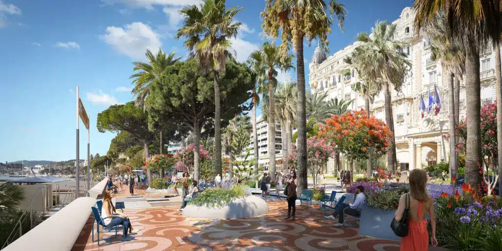 La Croisette à Cannes avec promenade bordée de palmiers, jardins fleuris et vue sur la mer.