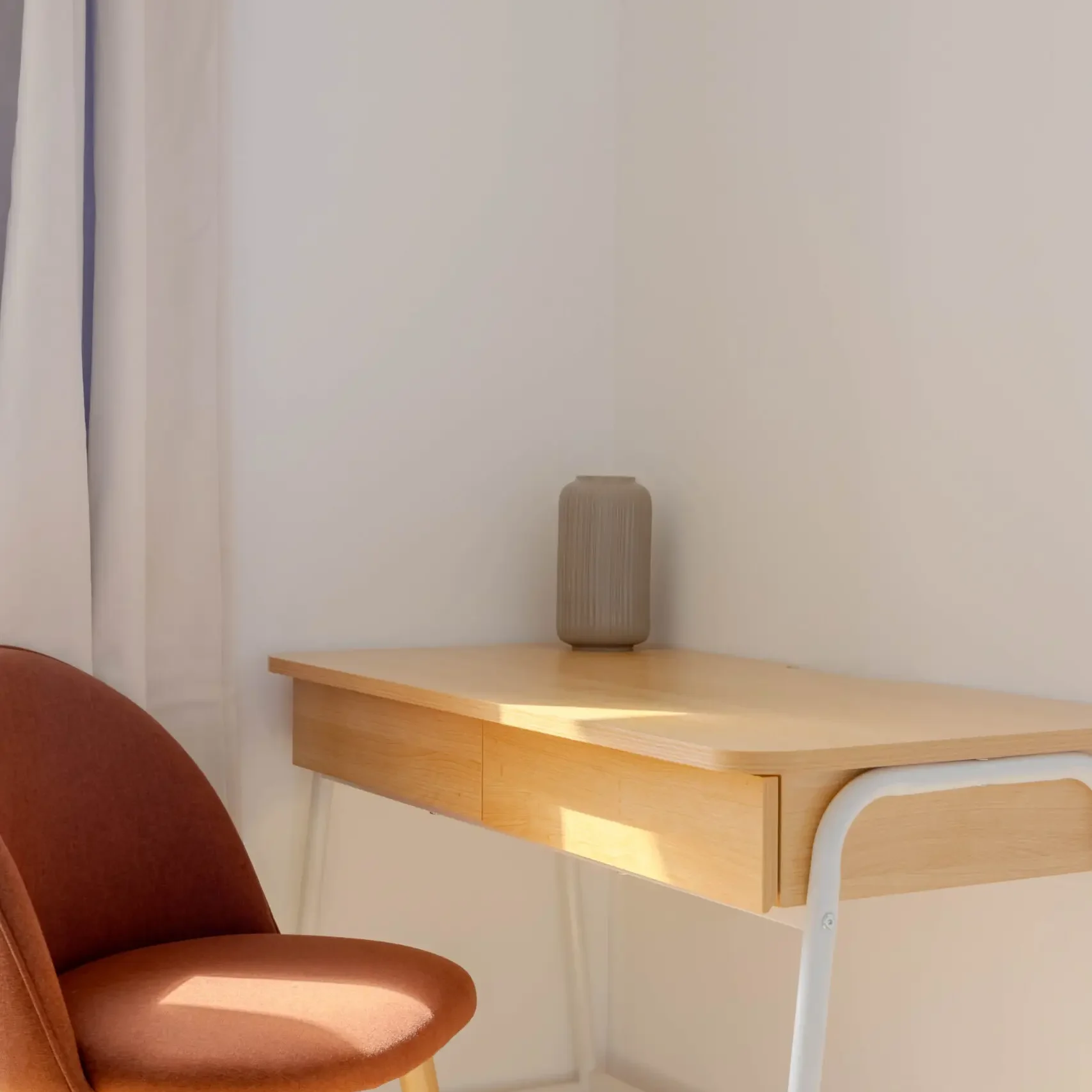 Petit bureau lumineux avec chaise confortable, idéal pour télétravailler ou poser son ordinateur portable en toute tranquilité.