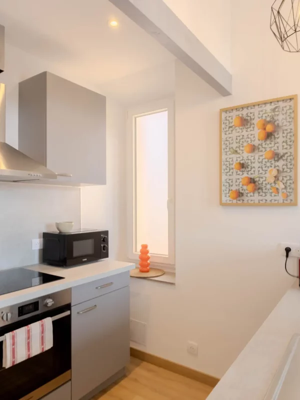 Cuisine fonctionnelle avec rangements, électroménager récent et lumière naturelle pour cuisiner dans un cadre agréable.
