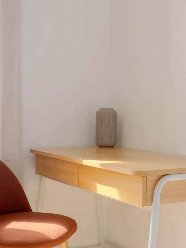 Petit bureau lumineux avec chaise confortable, idéal pour télétravailler ou poser son ordinateur portable en toute tranquilité.